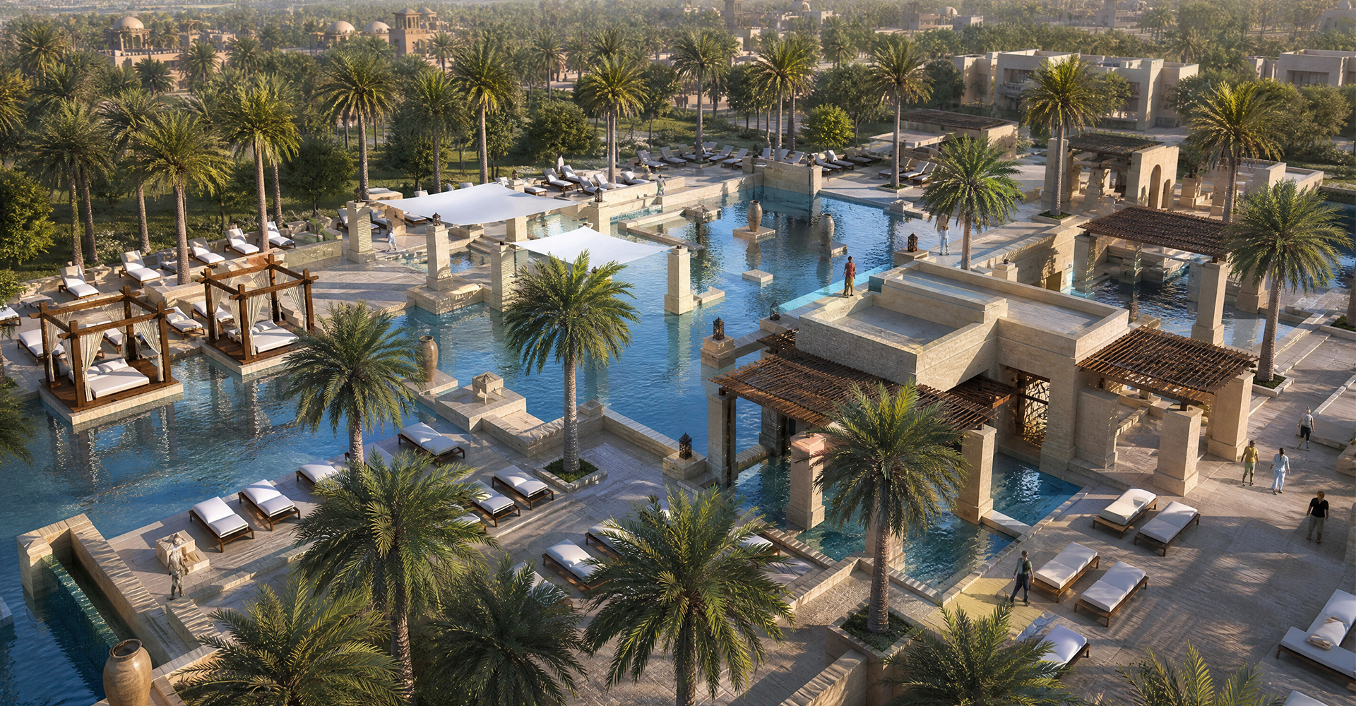 Aerial view of a luxury resort pool with cabanas, sun loungers, palm trees, and expansive water features.